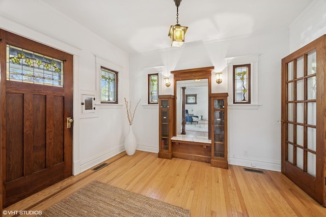 foyer entrance with light wood-style flooring and baseboards