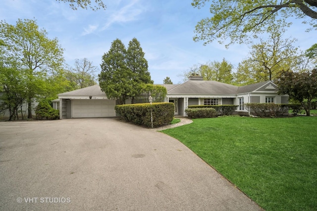 419 Sheridan Rd, Highland Park, IL 60035 - view of front facade with asphalt driveway, a garage, a front yard, and a chimney