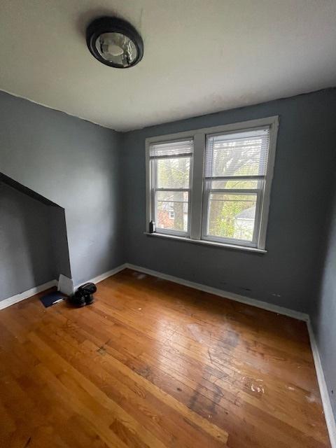 empty room featuring baseboards and wood finished floors