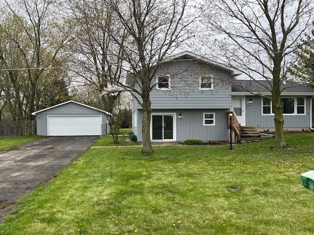 split level home featuring an outdoor structure, a detached garage, a front lawn, and fence