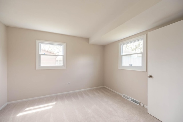 unfurnished room with baseboards, light carpet, and visible vents