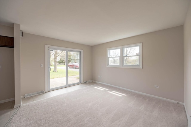 empty room featuring visible vents, baseboards, and light carpet
