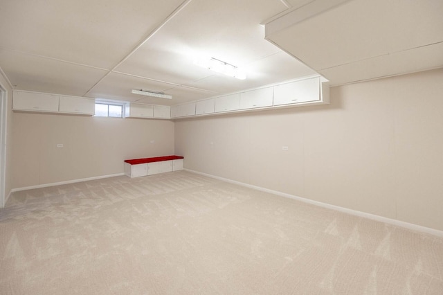 below grade area with light carpet and baseboards