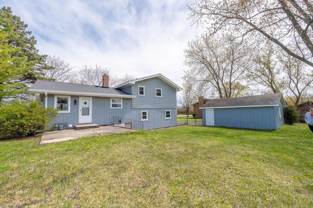 rear view of property featuring an outdoor structure, a yard, a patio, a chimney, and board and batten siding
