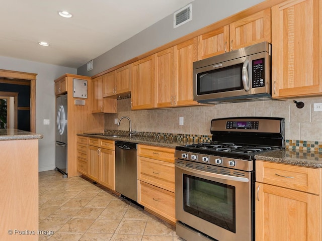 kitchen featuring visible vents, decorative backsplash, light brown cabinets, and stainless steel appliances