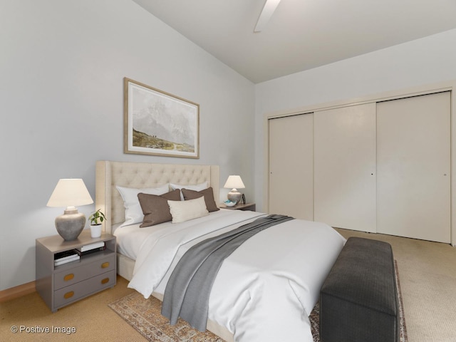 bedroom with a ceiling fan, light colored carpet, and a closet