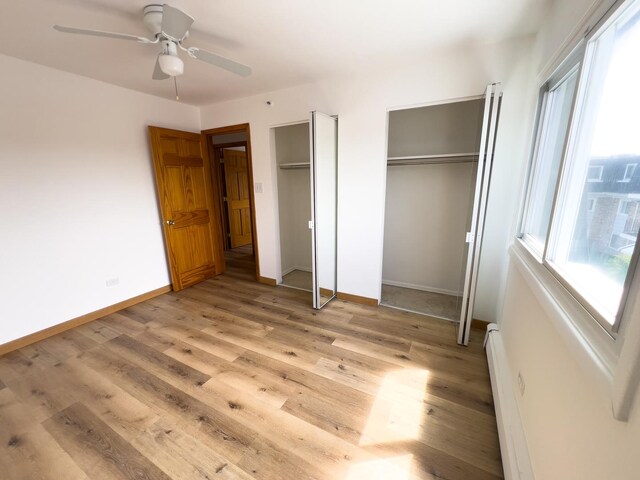 10310 Ridgeland Ave Unit 307, Chicago Ridge, IL 60415 - unfurnished bedroom featuring a ceiling fan, two closets, light wood-style flooring, and baseboards