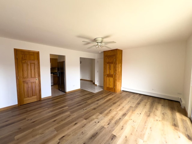 10310 Ridgeland Ave Unit 307, Chicago Ridge, IL 60415 - unfurnished bedroom with baseboards, baseboard heating, black fridge, and wood finished floors