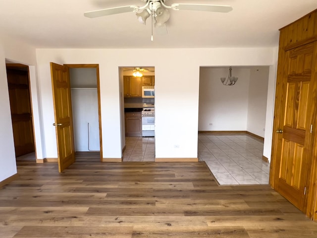 10310 Ridgeland Ave Unit 307, Chicago Ridge, IL 60415 - unfurnished bedroom featuring connected bathroom, light wood-type flooring, baseboards, and ceiling fan