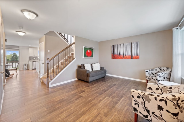 living room featuring baseboards, stairs, and wood finished floors