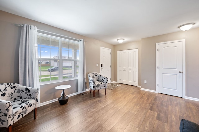 living area featuring baseboards, wood finished floors, and visible vents