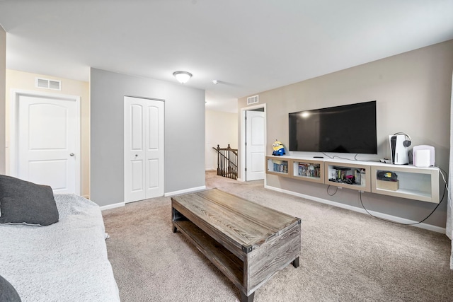 living room featuring visible vents, carpet, and baseboards