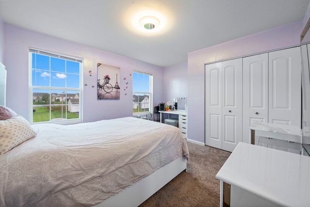 bedroom with baseboards, a closet, and dark colored carpet