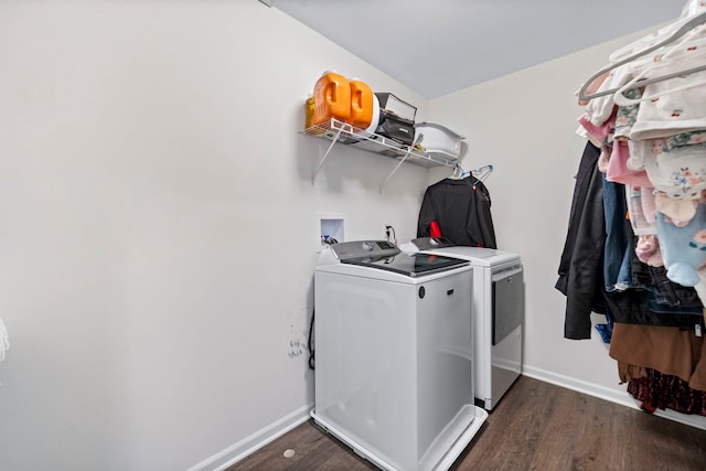 laundry area with laundry area, washer and clothes dryer, baseboards, and wood finished floors