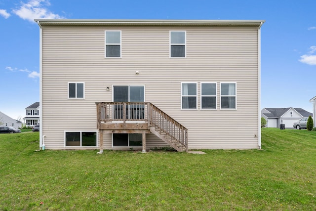 back of house with stairway, a lawn, and a deck