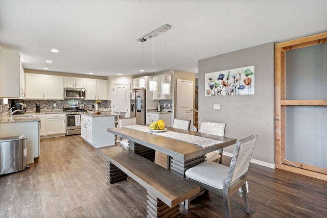 dining area with dark wood-style flooring, baseboards, and recessed lighting