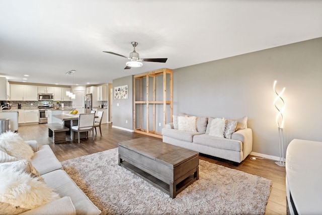 living area featuring recessed lighting, baseboards, ceiling fan, and light wood-style flooring