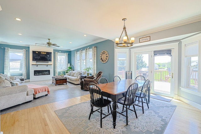 dining area with crown molding, healthy amount of natural light, a chandelier, light wood-style flooring, and recessed lighting