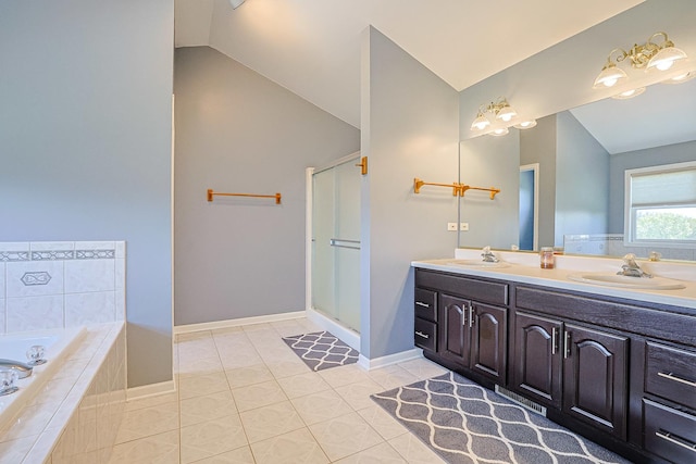 bathroom with lofted ceiling, double vanity, a garden tub, tile patterned floors, and baseboards
