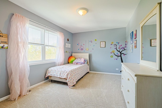 bedroom featuring light carpet and baseboards