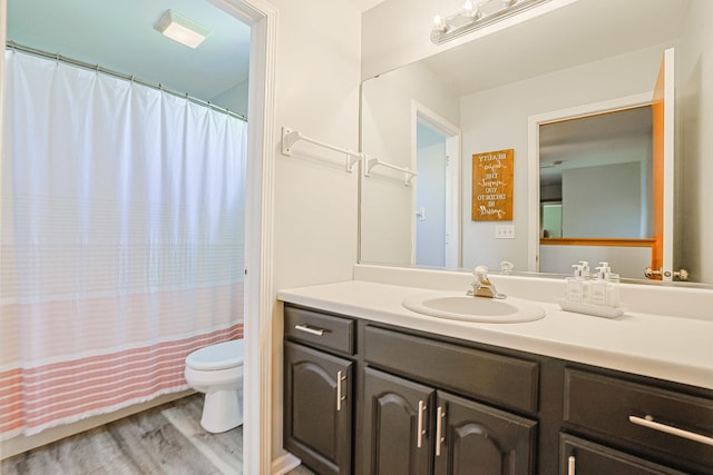 full bathroom featuring toilet, wood finished floors, vanity, and curtained shower