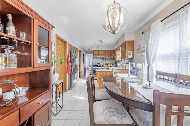 dining room with light tile patterned floors, a notable chandelier, and a wealth of natural light
