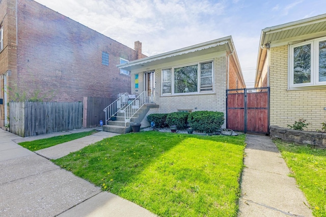 split level home with fence, a chimney, a front yard, and brick siding