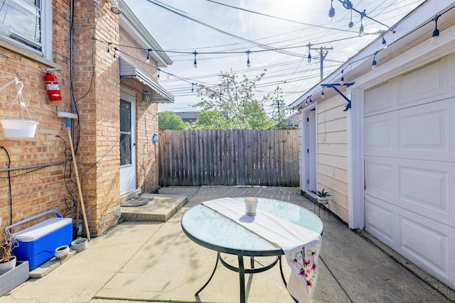 view of patio / terrace with a garage and fence