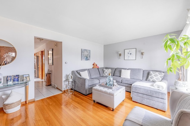 living room with baseboards and light wood finished floors