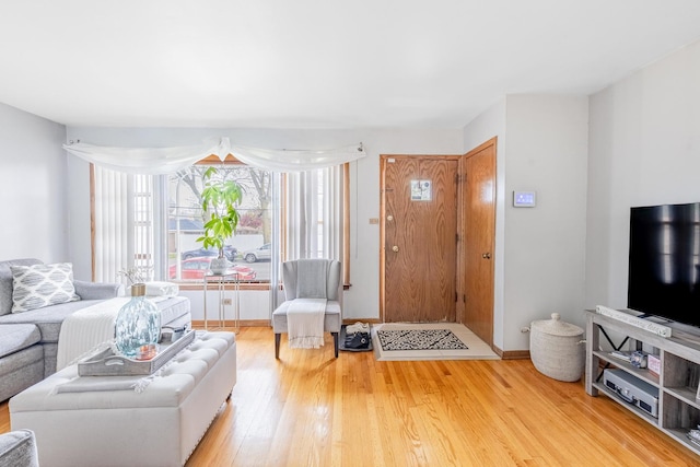 living area with baseboards and wood finished floors