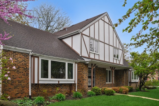 23 Westmoreland Ln, Naperville, IL 60540 - tudor home with board and batten siding, a shingled roof, a front lawn, and brick siding