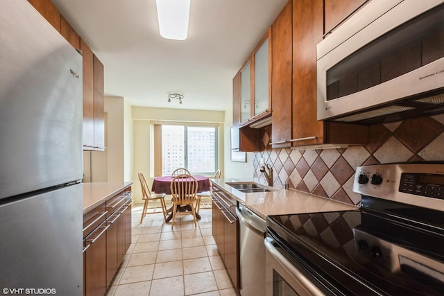 7033 N Kedzie Ave Unit 914, Chicago, IL 60645 - kitchen with stainless steel appliances, a sink, decorative backsplash, and brown cabinets