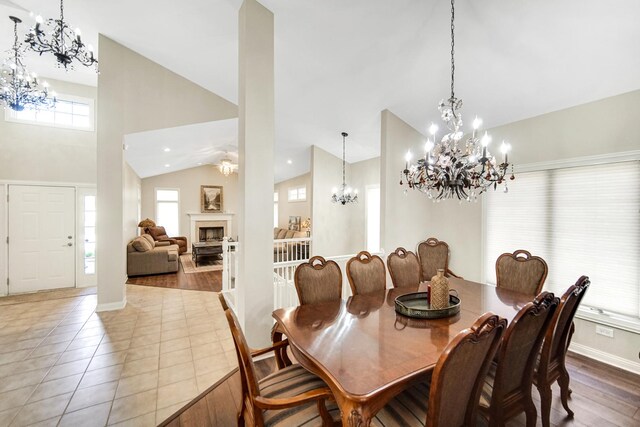 13083 Timber Ct, Palos Heights, IL 60463 - dining area with a notable chandelier, a fireplace, tile patterned floors, high vaulted ceiling, and baseboards