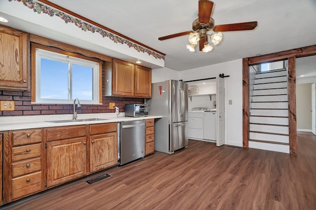 23678 N 2700 E Rd, Odell, IL 60460 - kitchen with stainless steel appliances, washer and clothes dryer, a sink, dark wood finished floors, and brown cabinets