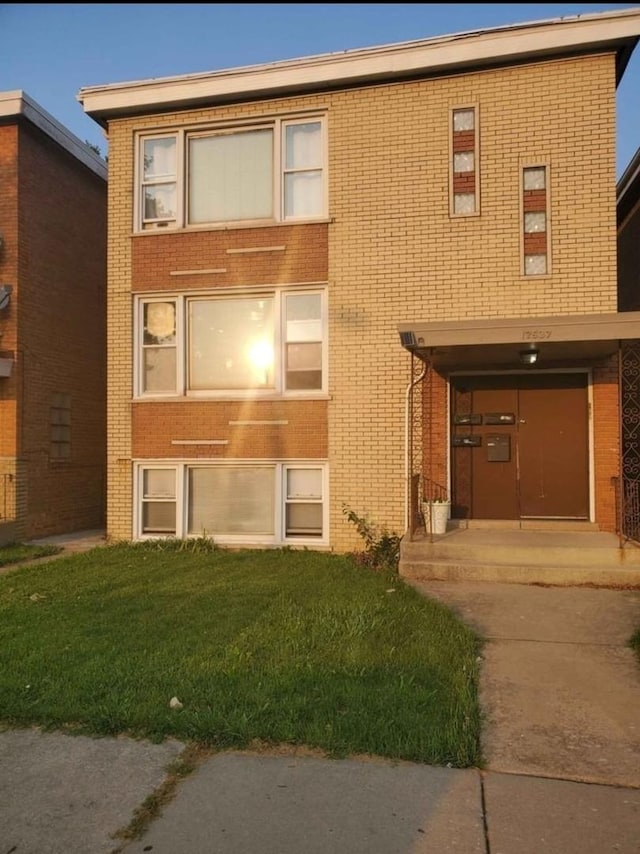 multi unit property with brick siding and a front lawn
