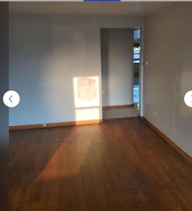 unfurnished room with baseboards and wood finished floors