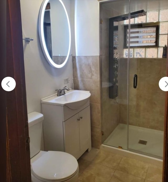 full bath featuring tile patterned floors, toilet, vanity, and a stall shower