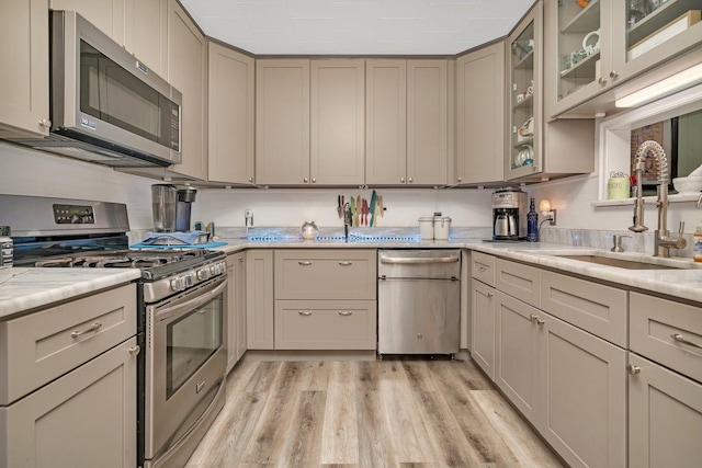 5203 W Court St, Monee, IL 60449 - kitchen with appliances with stainless steel finishes, a sink, light wood-type flooring, glass insert cabinets, and light stone counters