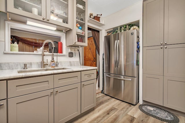 5203 W Court St, Monee, IL 60449 - kitchen with freestanding refrigerator, a sink, light wood-style flooring, light countertops, and glass insert cabinets