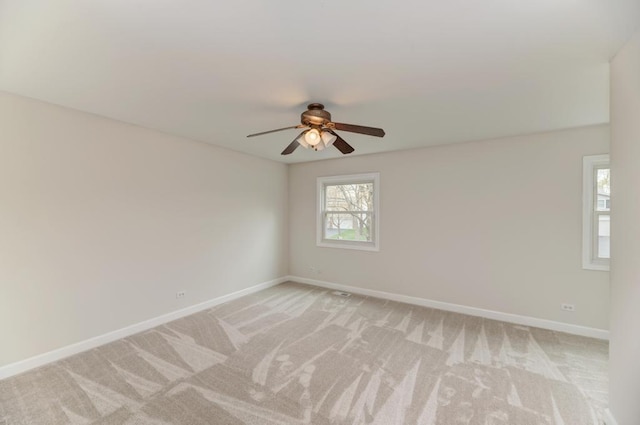 unfurnished room with ceiling fan, light carpet, and baseboards