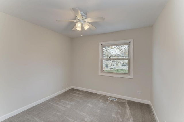 carpeted spare room featuring a ceiling fan, baseboards, and visible vents