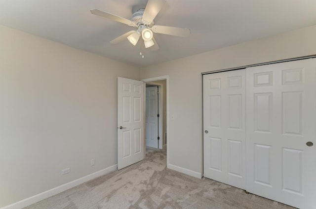 unfurnished bedroom with baseboards, a ceiling fan, a closet, and light carpet