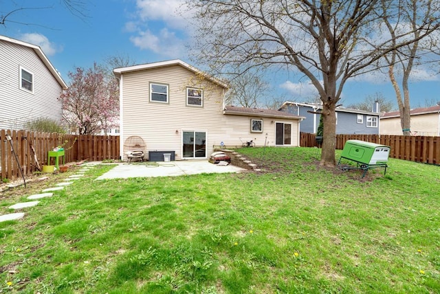 rear view of house featuring a lawn, a fenced backyard, and a patio area