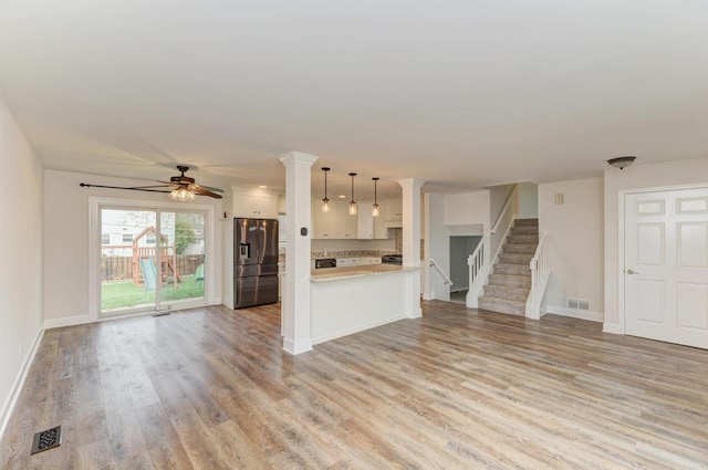 kitchen with visible vents, open floor plan, stainless steel fridge, light countertops, and a ceiling fan