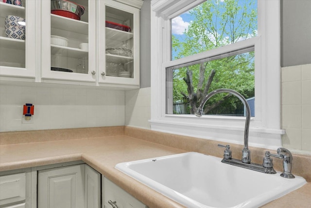 2603 Trafalgar Sq, Champaign, IL 61821 - kitchen with white appliances, a sink, under cabinet range hood, wainscoting, and white cabinets