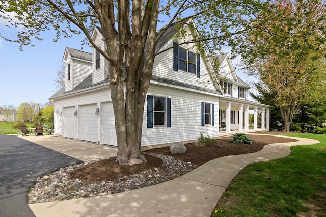 view of property exterior featuring a porch and aphalt driveway