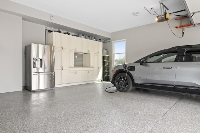 garage featuring stainless steel fridge with ice dispenser and a garage door opener