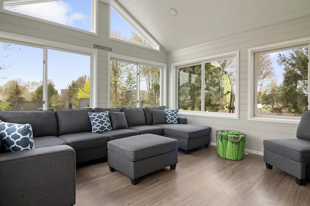 sunroom with high vaulted ceiling, wood finished floors, and a deck