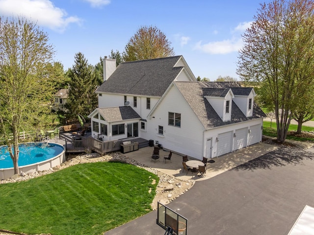 view of side of property with a yard, a deck, a chimney, and roof with shingles