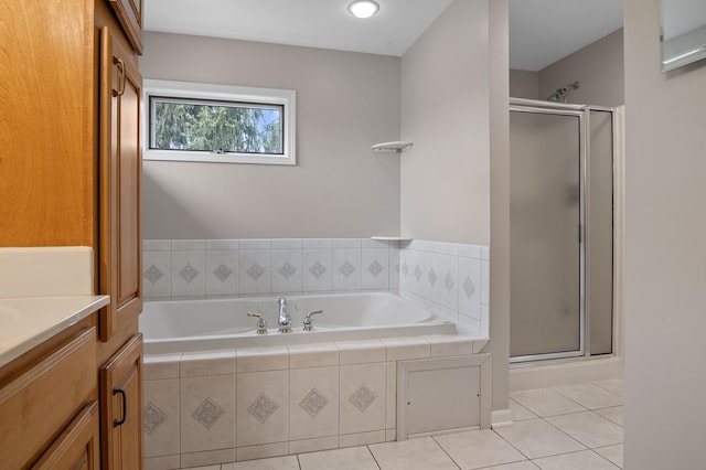 full bath with vanity, tile patterned floors, a bath, and a stall shower